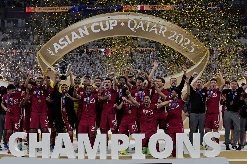 The Qatar team poses with the trophy at the end of the Asian Cup final soccer match between Qatar and Jordan at the Lusail Stadium in Lusail, Qatar, Saturday, Feb. 10, 2024. (AP Photo/Thanassis Stavrakis)