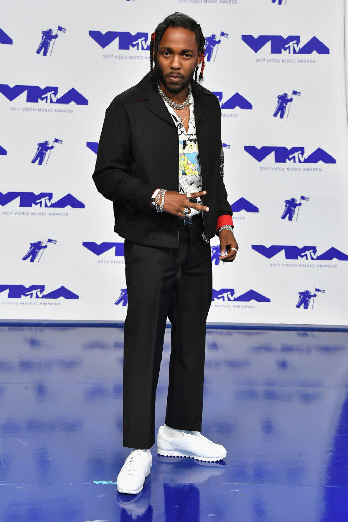 <p>Kendrick Lamar paired white sneakers with a black suit and colorful collared shirt. (Photo: AP) </p>