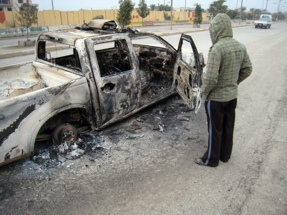 A man looks at a burned police vehicle in the main street of Fallujah after clashes between Iraqi security forces and al-Qaeda fighters in Fallujah, 40 miles (65 kilometers) west of Baghdad, Iraq, Sunday, Jan. 5, 2014. Lt. Gen. Rasheed Fleih, who leads the Anbar Military Command, told the state television Sunday that "two to three days" are needed to push the militants out of Fallujah and parts of Ramadi. (AP Photo)