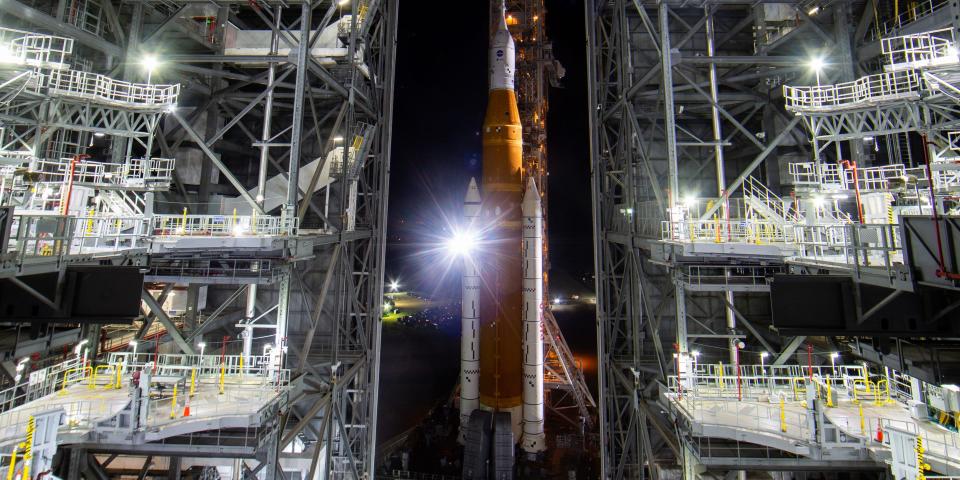 NASA's SLS rocket is shown being rolled out of an assembly hanger.