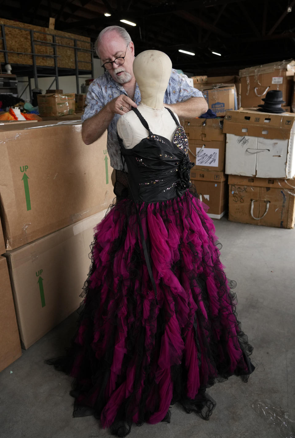 Shon LeBlanc, co-owner of costume rental service Valentino's Costume Group, primps a popular dress item, Friday, May 26, 2023, at his warehouse in Los Angeles. (AP Photo/Chris Pizzello)