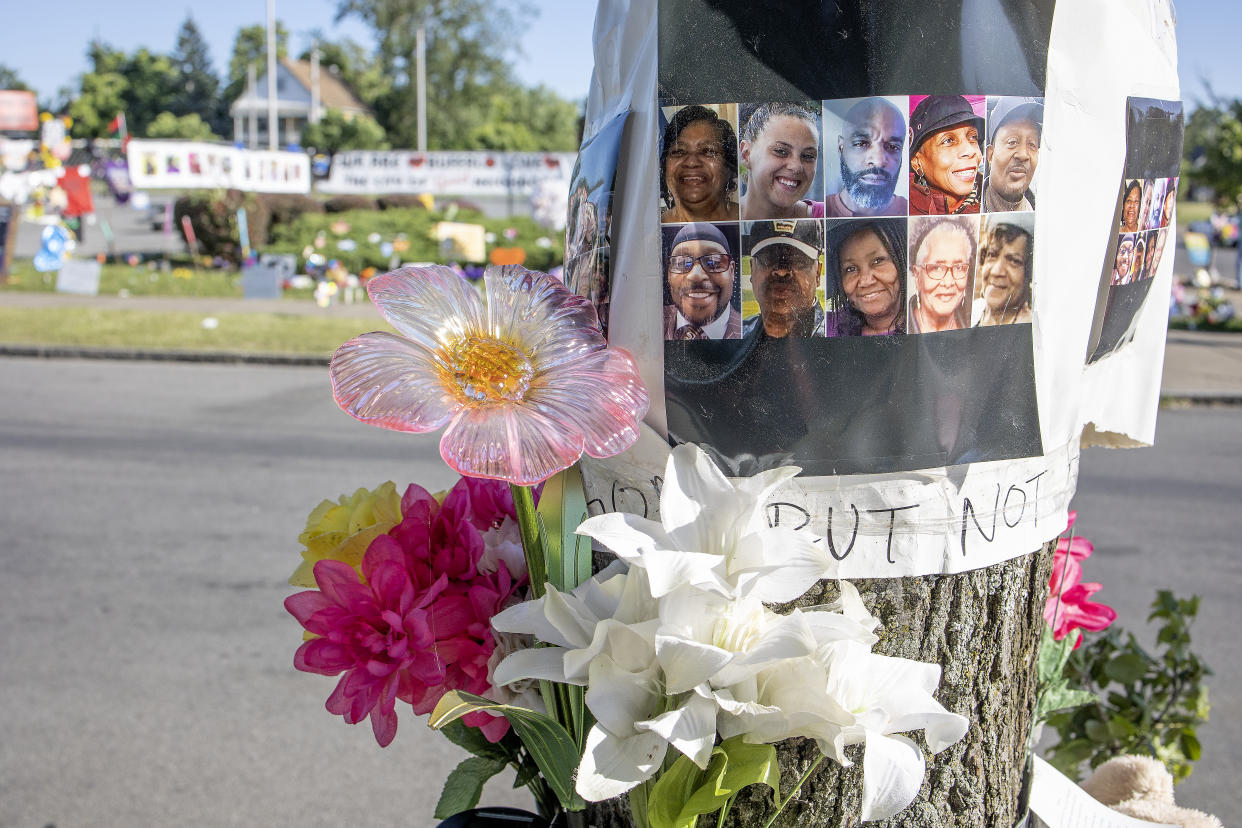 Flowers and images of the victims are attached to a telephone pole.