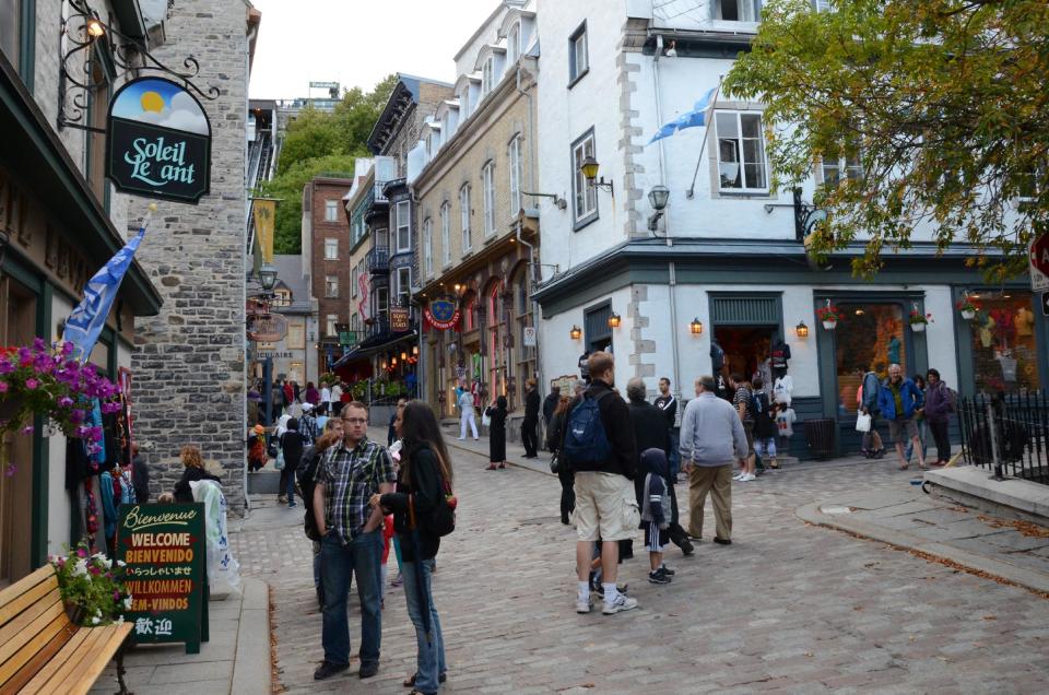 In this Aug. 13, 2013 photo, people meander through the streets of Old Quebec in Montreal. Quebec City is the starting point for many cyclists traveling east along the St. Lawrence River through quiet villages overlooking sweeping river vistas. (AP Photo/Calvin Woodward)