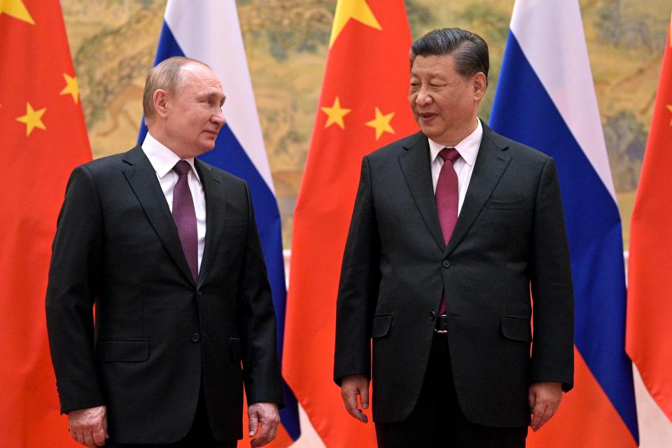 Chinese President Xi Jinping, right, and Russian President Vladimir Putin talk to each other during their meeting in Beijing, China, Friday, Feb. 4, 2022.