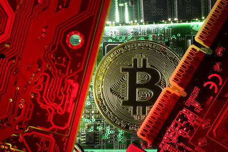 FILE PHOTO: A coin representing the bitcoin cryptocurrency is seen on computer circuit boards in this illustration picture, October 26, 2017. REUTERS/Dado Ruvic/File Photo