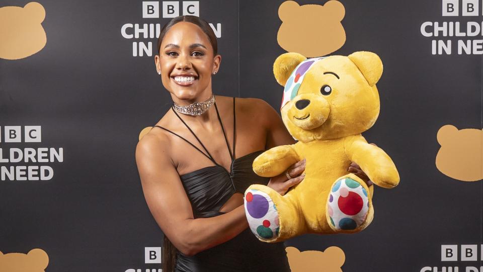 Alex in black dress holding pudsey bear