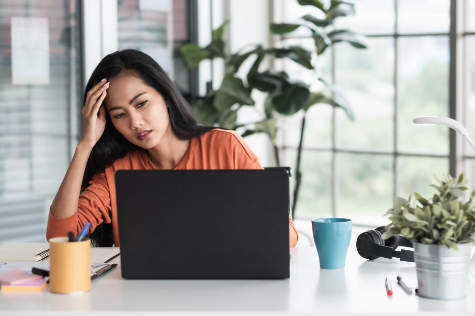 woman stressed about project in front of laptop while working from home.