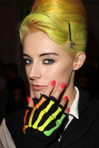 <b>PPQ </b><br><br>This unique beauty look featured yellow bouffant hair and coral coloured nails.<br><br>Image © Getty