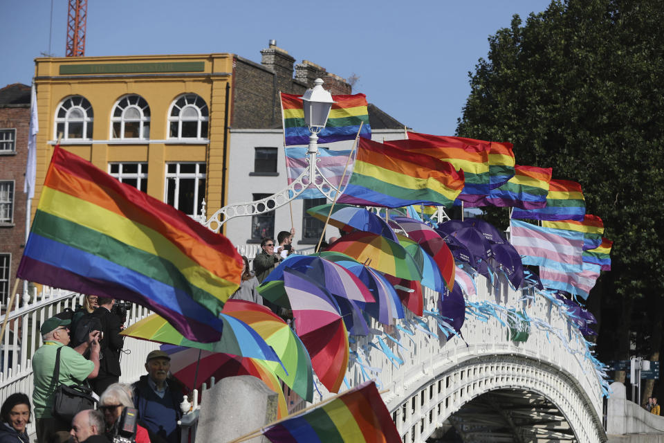 Rainbow flags and blue ribbons are tied to Ha'Penny Bridge, Dublin to remember the victims of Catholic Church clerical sex abuse, ahead of the arrival of Pope Francis, in Dublin, Ireland, Saturday, Aug. 25, 2018. The pontiff is traveling to Ireland for a two-day visit on the occasion of the 2018 World Meeting of Families. (Niall Carson/PA via AP)