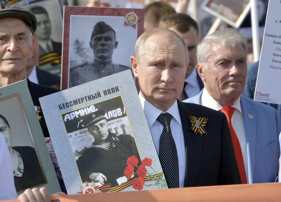 FILE - Russian President Vladimir Putin, center, holds a portrait of his father Vladimir Spiridonovich Putin, in front of him, as he walks among other people carrying portraits of relatives who fought in World War II, during the Immortal Regiment march through Red Square celebrating 74 years since the victory in WWII in Red Square in Moscow, Russia, Thursday, May 9, 2019. The defeat of Nazi Germany in World War II that Russia celebrates on May 9 is the country's most important holiday. This year it has special meaning amid the war in Ukraine, which the Kremlin calls a "special military operation" aimed to rid the country of alleged "neo-Nazis" — a false accusation derided by the West. (Alexei Druzhinin, Sputnik, Kremlin Pool Photo via AP, File)