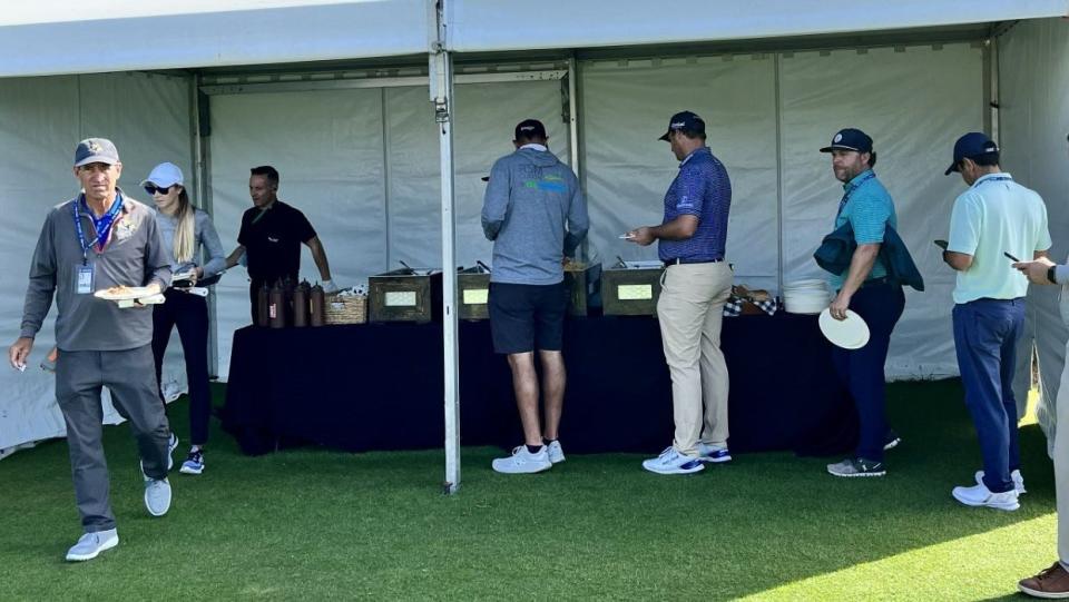 Players, caddies, coaches and equipment reps line up for Southern Soul barbecue on Tuesday at the Sea Island Club range. The popular St. Simons Island restaurant has catered a lunch on the range for the past several years and has a booth at the RSM Classic.