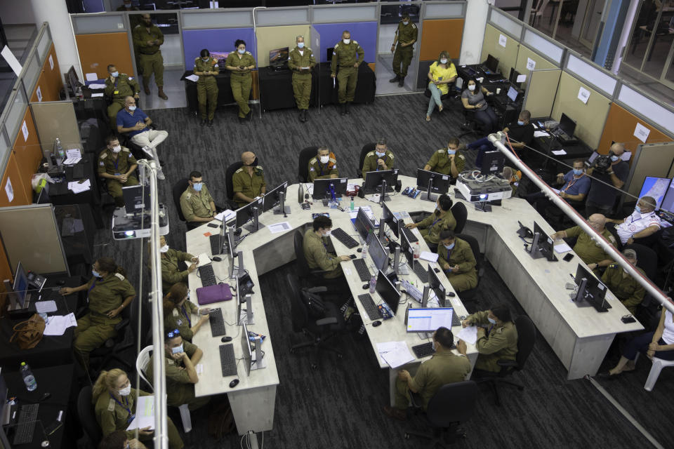 Soldiers work in a situation room at the headquarters of the Home Front Command, in Ramle, Central Israel, Tuesday, Aug. 25, 2020. As Israel struggles to control a coronavirus outbreak, it is calling in the army to help. At the instruction of the country's coronavirus czar, the military has set up a new "task force” that is playing a leading role in contact tracing and breaking the chain of infections. (AP Photo/Sebastian Scheiner)