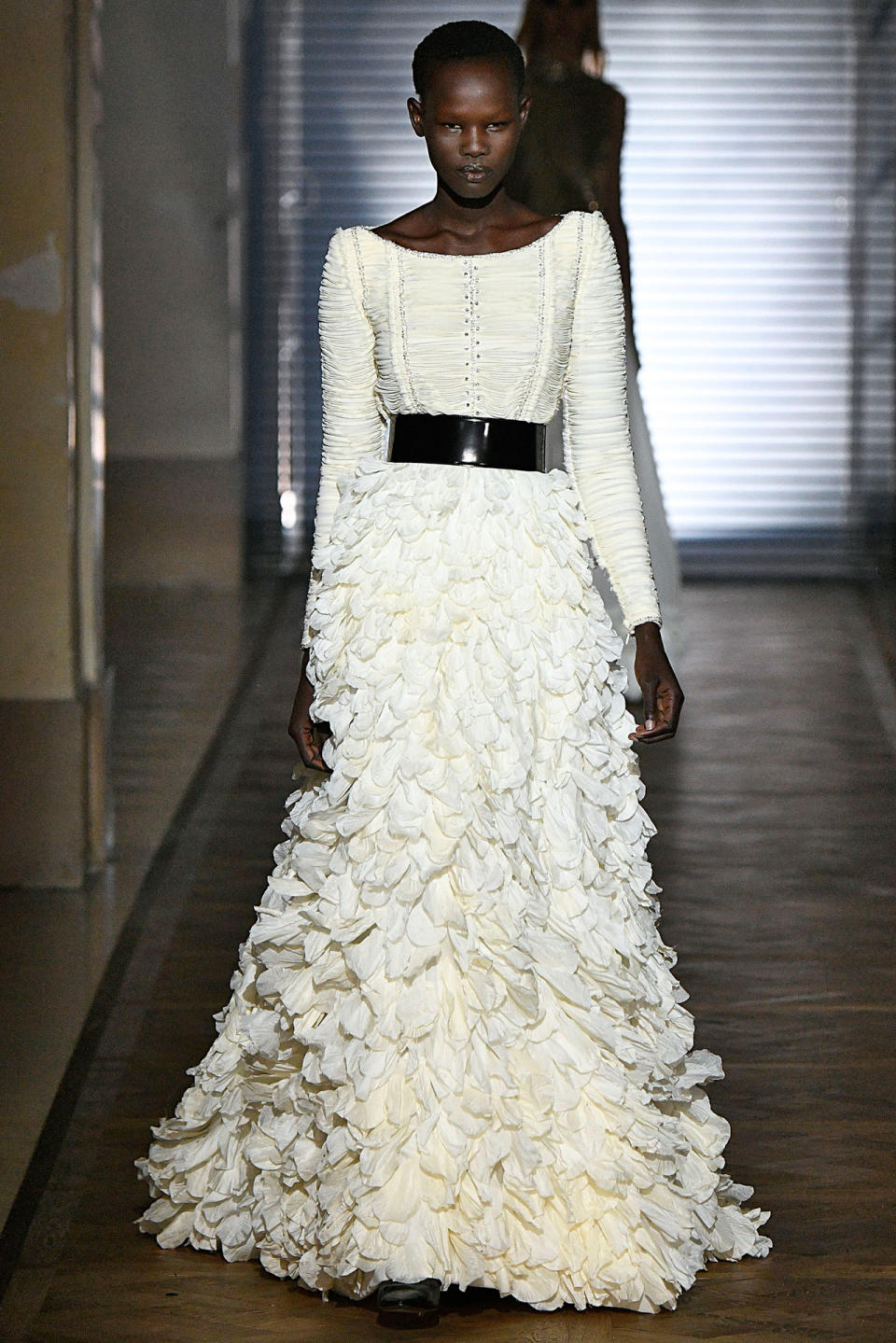 <p>Model wears a white, long-sleeved gown with petal appliqués from the Givenchy SS18 Haute Couture show. (Photo: Getty Images) </p>