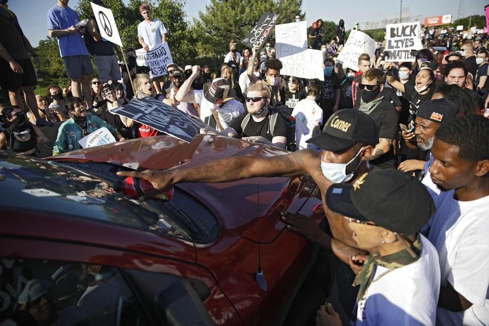 Protesters surround a truck shortly before it drove through the group injuring several on Interstate 244 in Tulsa, Okla., Sunday, May 31, 2020. (Mike Simons/Tulsa World via AP)