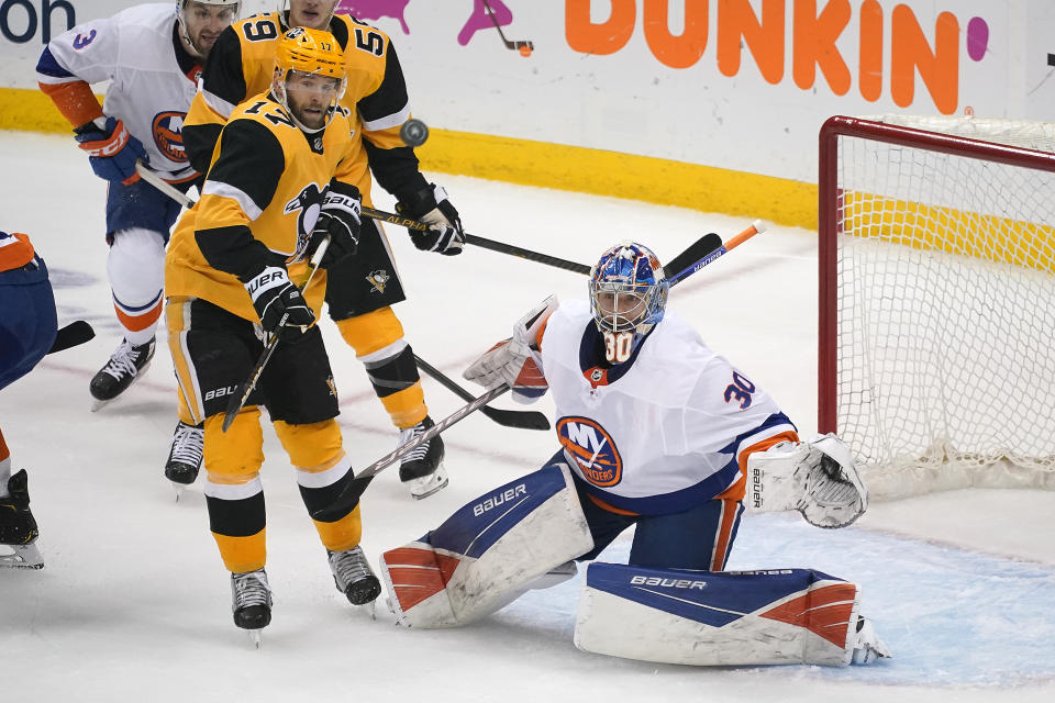 New York Islanders goaltender Ilya Sorokin (30) watches the puck with Pittsburgh Penguins' Bryan Rust (17) looking for a deflection during the first period in Game 5 of an NHL hockey Stanley Cup first-round playoff series in Pittsburgh, Monday, May 24, 2021. (AP Photo/Gene J. Puskar)