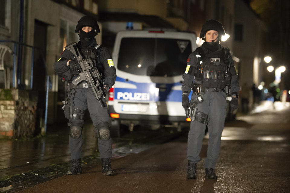 Armed police are seen at the site of a car crash during a carnival procession in Volkmarsen, Germany, Monday, Feb. 24, 2020. A man intentionally drove a car into a crowd of people at a Carnival parade in a small town in central Germany, injuring dozens of people including children, officials said Monday. Prosecutors said the driver, a 29-year-old local man, was arrested at the scene of the incident in Volkmarsen, about 280 kilometers (175 miles) southwest of Berlin. (Swen Pfortner/dpa via AP)