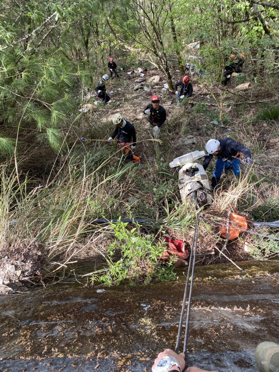 花蓮林區管理處結合攀岩垂降好手發起「大禹嶺淨山」活動，以繩索垂降至大禹嶺台14甲40.8K沿線公路邊坡下方及屏風山登山口附近清理廢棄物，包括報廢機車、洗衣機、金爐、汽油桶等。（圖／花蓮林區管理處提供）