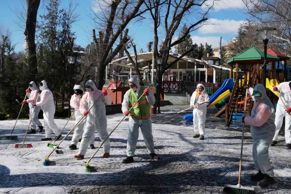 Municipality workers wearing face masks and protective suits disinfect Kugulu public garden amid the coronavirus outbreak, in Ankara, Turkey, on March 17.