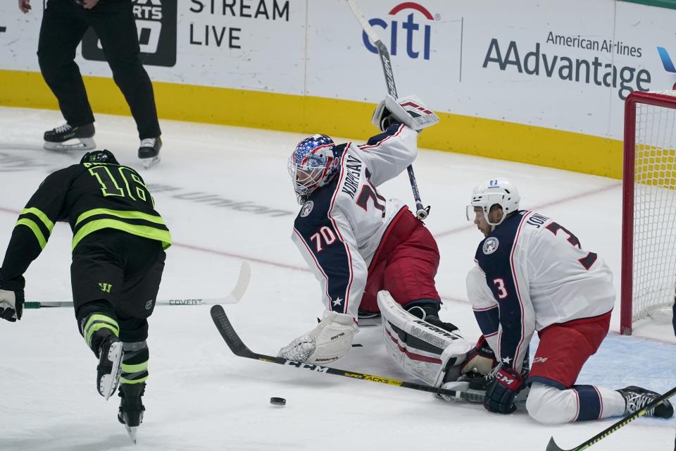 Dallas Stars center Joe Pavelski (16) shoots past Columbus Blue Jackets goaltender Joonas Korpisalo (70) and Seth Jones (3) to score in the first period of an NHL hockey game in Dallas, Saturday, March 6, 2021. (AP Photo/Tony Gutierrez)