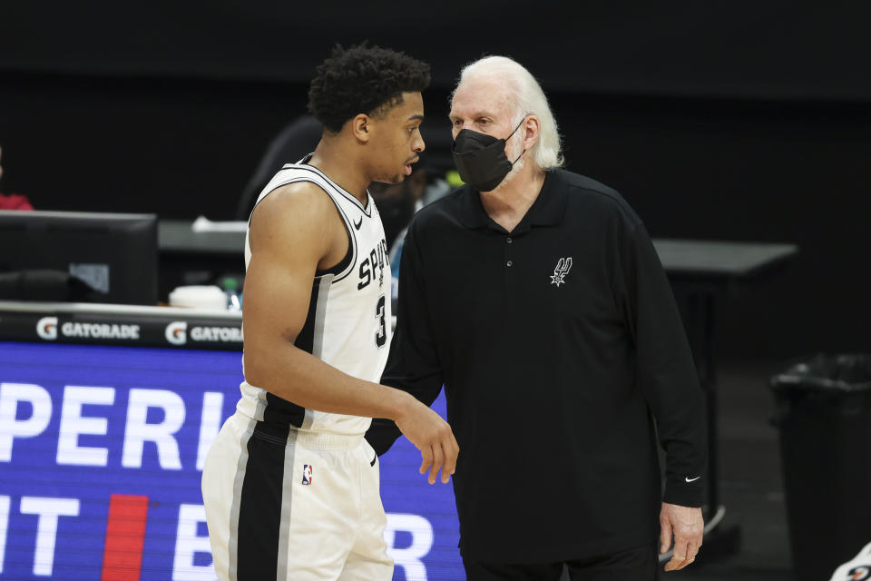 San Antonio Spurs coach Gregg Popovich, right, talks to San Antonio Spurs forward Keldon Johnson during the second half of an NBA basketball game against the Charlotte Hornets in Charlotte, N.C., Sunday, Feb. 14, 2021. (AP Photo/Nell Redmond)