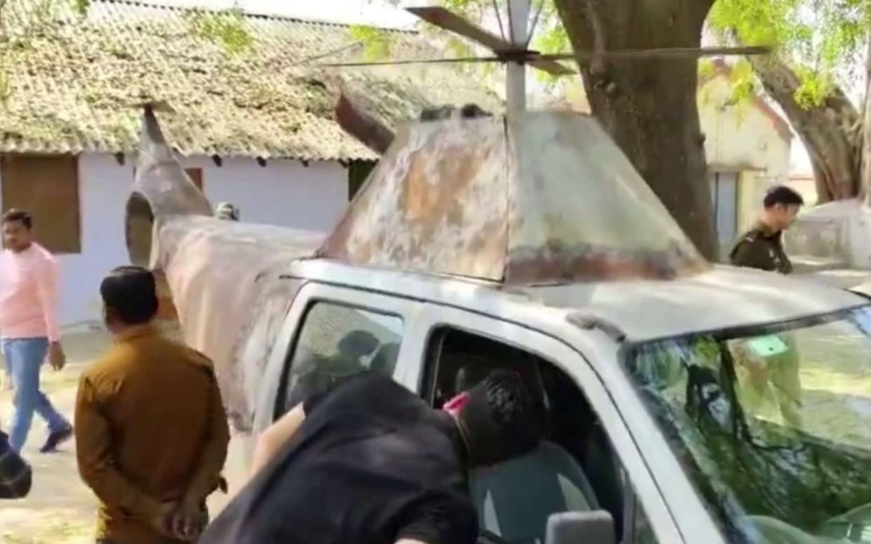 People inspect a car which has been converted into a helicopter in India