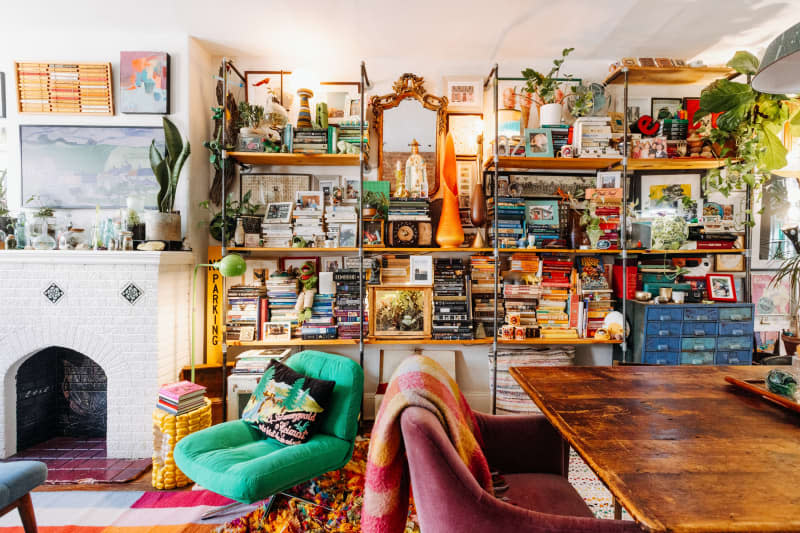 Shelves filled with books near a green chair.