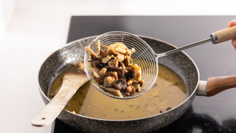 shiitake mushrooms on a slotted spoon 