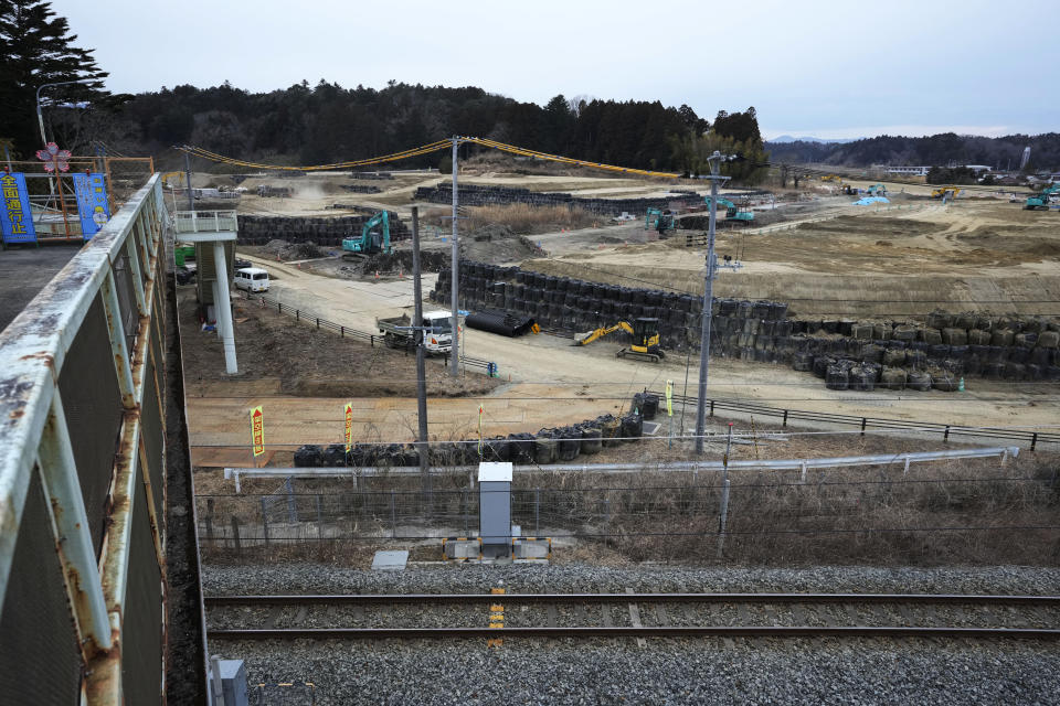 Workers operate heavy duty machines at a construction site of a planned apartment complex in Futaba, northeastern Japan, Tuesday, March 1, 2022. Until recently, Futaba, home to the Fukushima Daiichi nuclear plant, has been entirely empty of residents since the March 2011, disaster. A tiny section of the town has reopened for the first time since all 7,000 residents had to flee. (AP Photo/Hiro Komae)