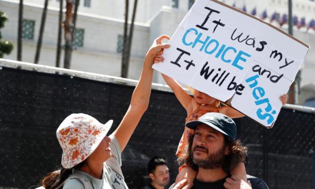People hold up a sign reading &#x002018;It was my choice and it will be hers&#x002019; during a rally outside city hall in Los Angeles.