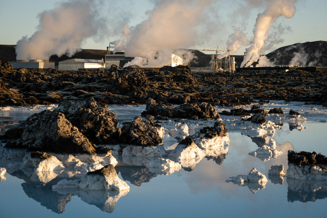 Plumes of steam rising from rocky ground in a snowy landscape.