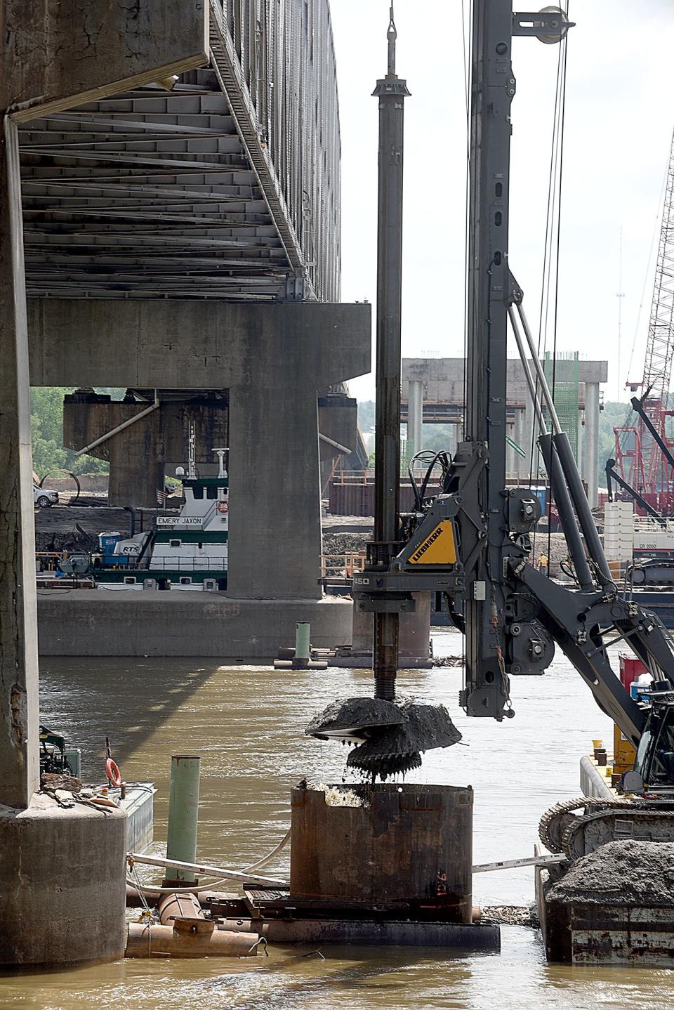 A driller raises the 11-foot diameter drill bit that is being used to drill holes for bridge pillars 50 feet below river water and another 20 feet into bedrock on Thursday at the new Lance Cpl. Leon Deraps' Interstate 70 Missouri River Bridge. The first bridge is expected to be completed in 2023 and the second bridge in 2024.