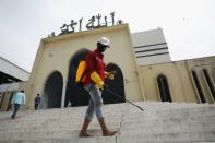 A volunteer sprays disinfectant in the Baitul Mukarram National Mosque before friday prayer amid concerns over the coronavirus disease (COVID-19) outbreak in Dhaka