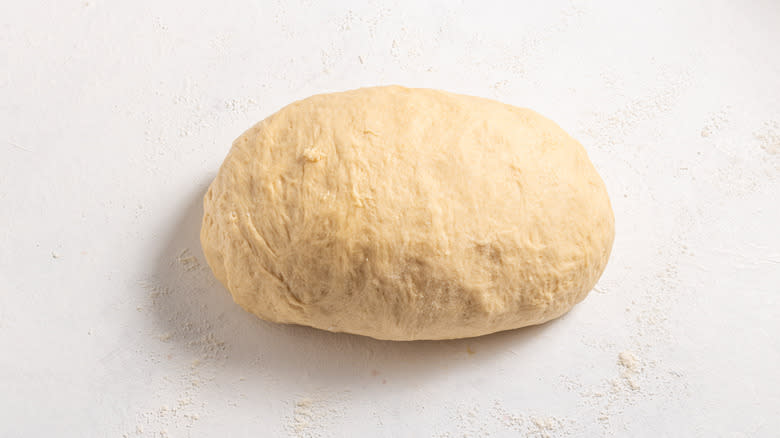 Dough shaped into an oval on a floured surface