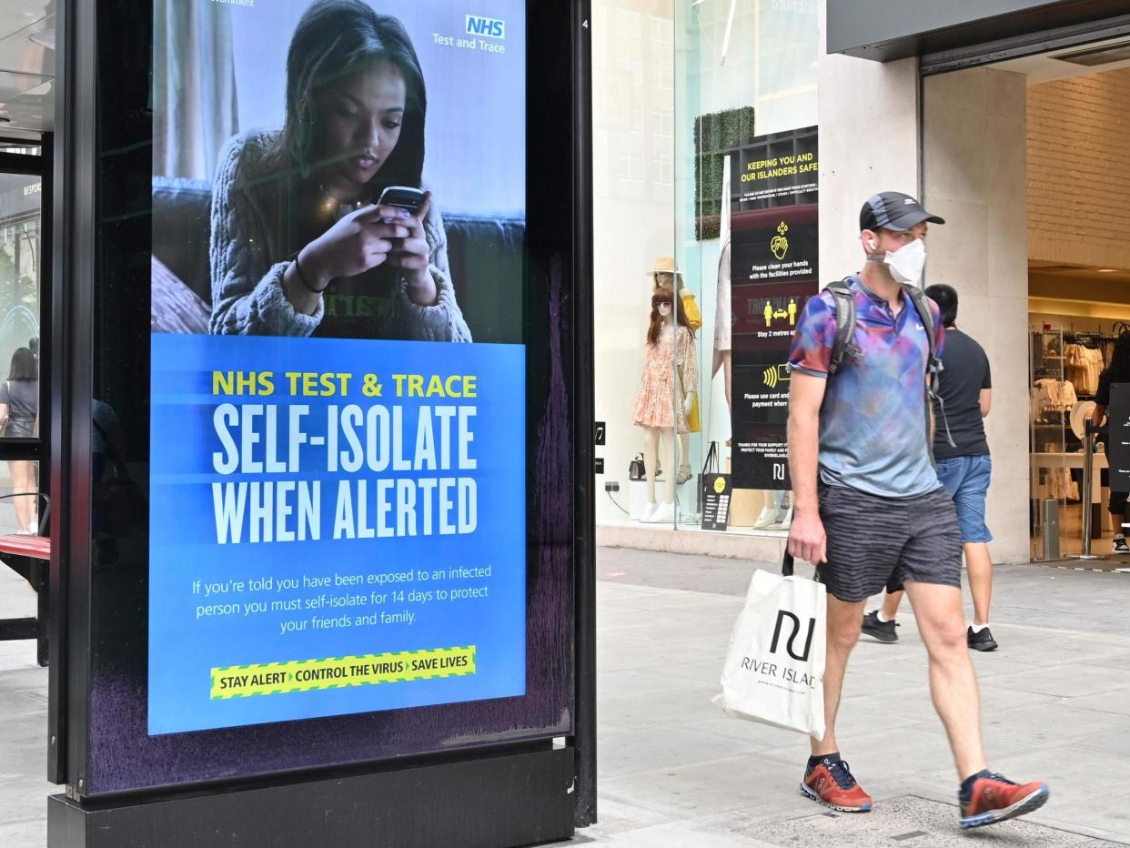 A shopper walks past an advertisment for the UK government's NHS Test and Trace system in Regent Street in London: GLYN KIRK/AFP via Getty Images