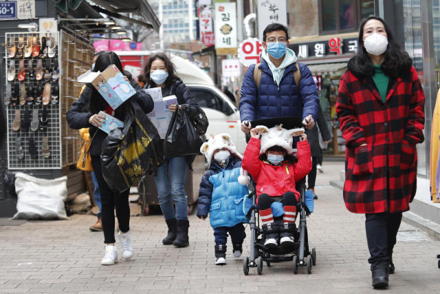People wear masks at a shopping district in Seoul, South Korea, Tuesday, Jan. 28, 2020. Panic and pollution drive the market for protective face masks, so business is booming in Asia, where fear of the coronavirus from China is straining supplies and helping make mask-wearing the new normal. (AP Photo/Ahn Young-joon)