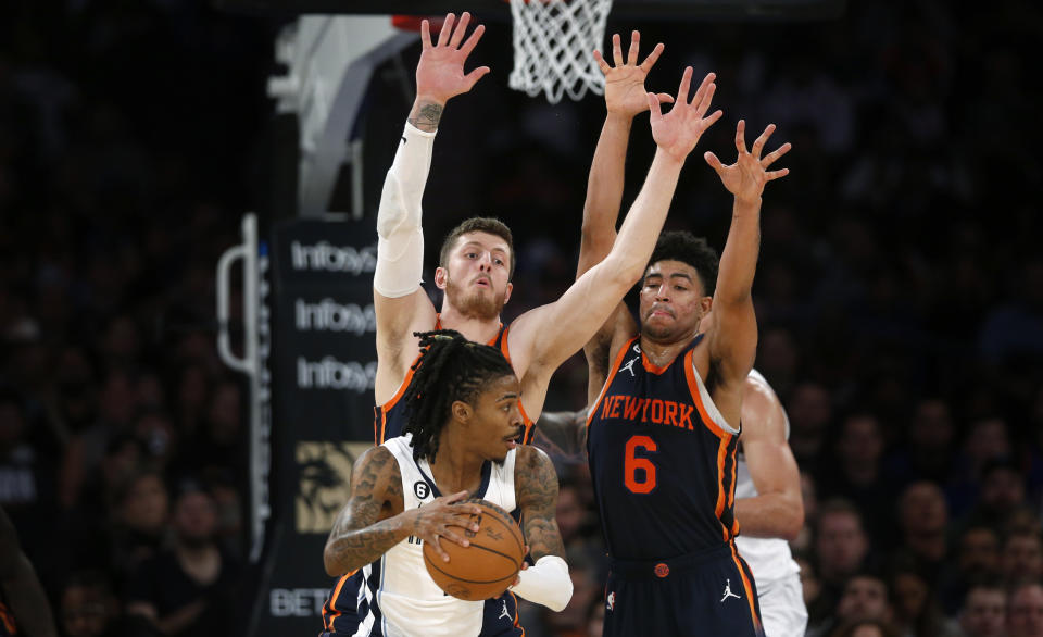 Memphis Grizzlies guard Ja Morant, with the ball, is defended by New York Knicks center Isaiah Hartenstein, left, and guard Quentin Grimes (6) during the first half of an NBA basketball game, Sunday, Nov. 27, 2022, in New York. (AP Photo/John Munson)