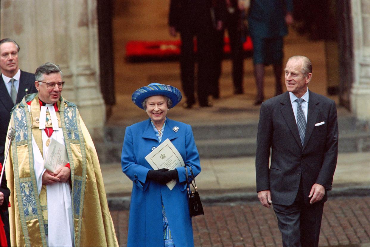 Britain's Queen Elizabeth II (C) and Prince Philip (R) in jovial mood after thanking the Dean of Westminster (L) for a special service at Westminster Abbey to celebrate their 50th Wedding Aniversary, leave the Westminster Abbey on November 20, 1997. The couple went on to meet hundreds of wellwishers who lined the streets outside the Abbey. 
AFP/POOL/GERRY PENNY (Photo by GERRY PENNY / POOL / AFP) (Photo by GERRY PENNY/POOL/AFP via Getty Images)