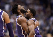 TCU guards Mike Miles Jr., left, and Shahada Wells (13) embrace during a timeout in the first half of an NCAA college basketball game against Kansas on Saturday, Jan. 21, 2023, at Allen Fieldhouse in Lawrence, Kan. (AP Photo/Nick Krug)