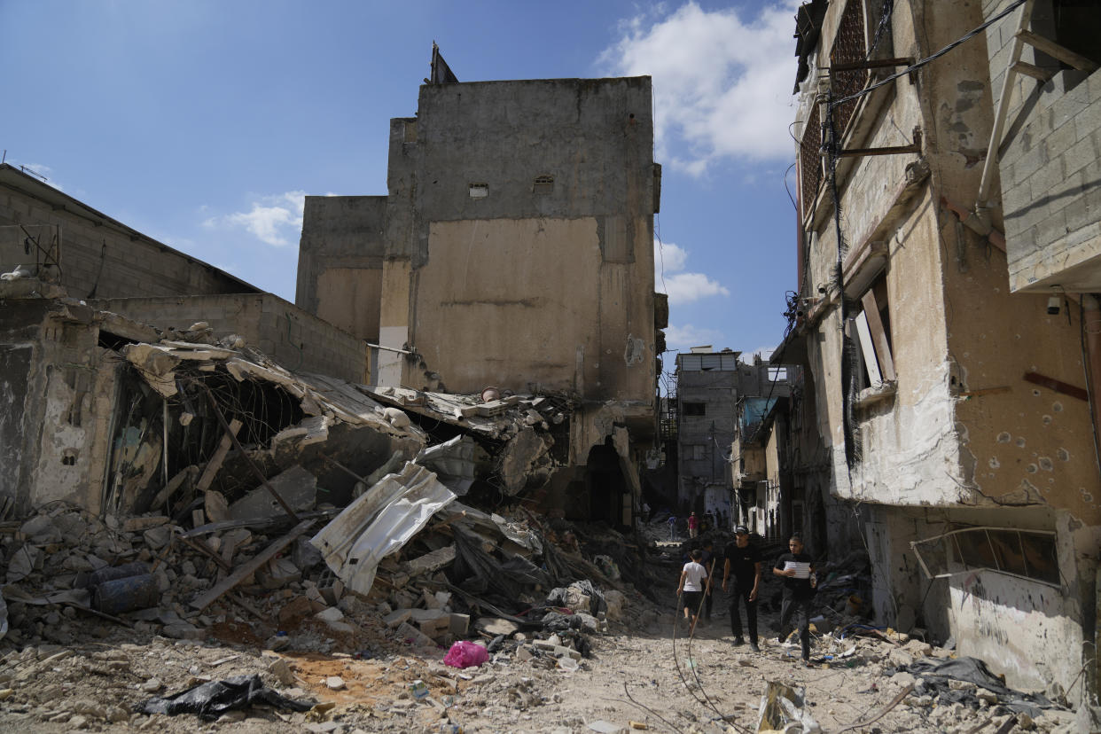 Palestinian refugees walk past the rubble of houses that were destroyed during the Israeli army operation in the West Bank refugee camp of Tulkarem, in Tulkarem, Thursday, Sept. 5, 2024. (AP Photo/Nasser Nasser)