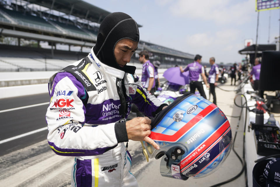 Takuma Sato, of Japan, puts on his helmet during practice for the Indianapolis 500 auto race at Indianapolis Motor Speedway, Thursday, May 19, 2022, in Indianapolis. (AP Photo/Darron Cummings)