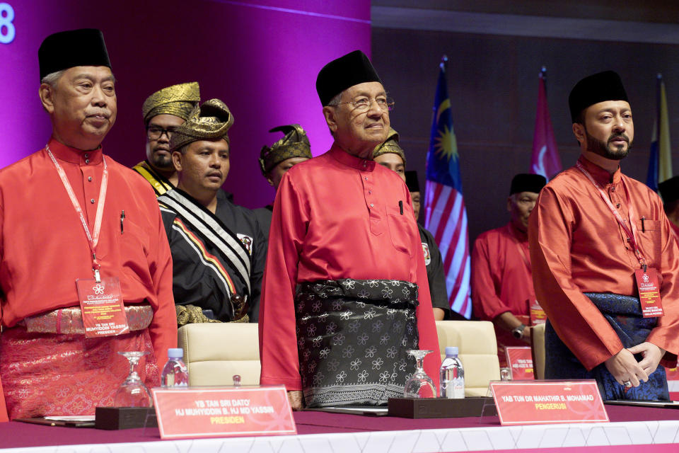 FILE- In this Dec. 29, 2018, file photo, Malaysian Prime Minster Mahathir Mohamad, center, stands next to his son Malaysian United Indigenous Party Vice President Mukhriz Mahathir, right, and President Muhyiddin Yassin, left, during the Malaysian United Indigenous Party general assembly at Putrajaya International Convention Centre in Putrajaya, Malaysia. Former Prime Minister Mahathir has been ousted from his Malay party in the latest twist to a power struggle with his successor Muhyiddin Yassin, but he has vowed to challenge the move. The 94-year-old Mahathir, along with his son and three other senior members, were expelled from the Bersatu party on Thursday, May 28, 2020. (AP Photo/Yam G-Jun, File)