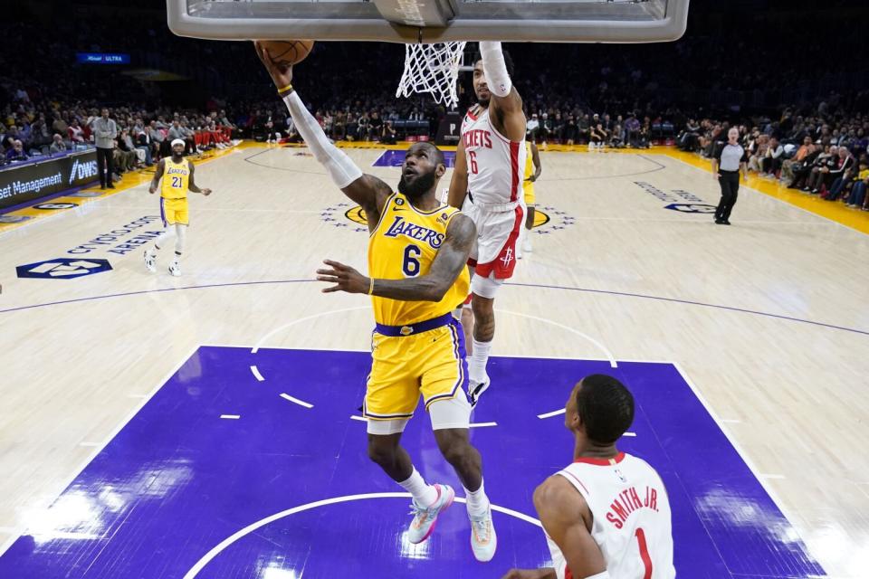 LeBron James scores in front of Houston's Kenyon Martin Jr. during the first half.