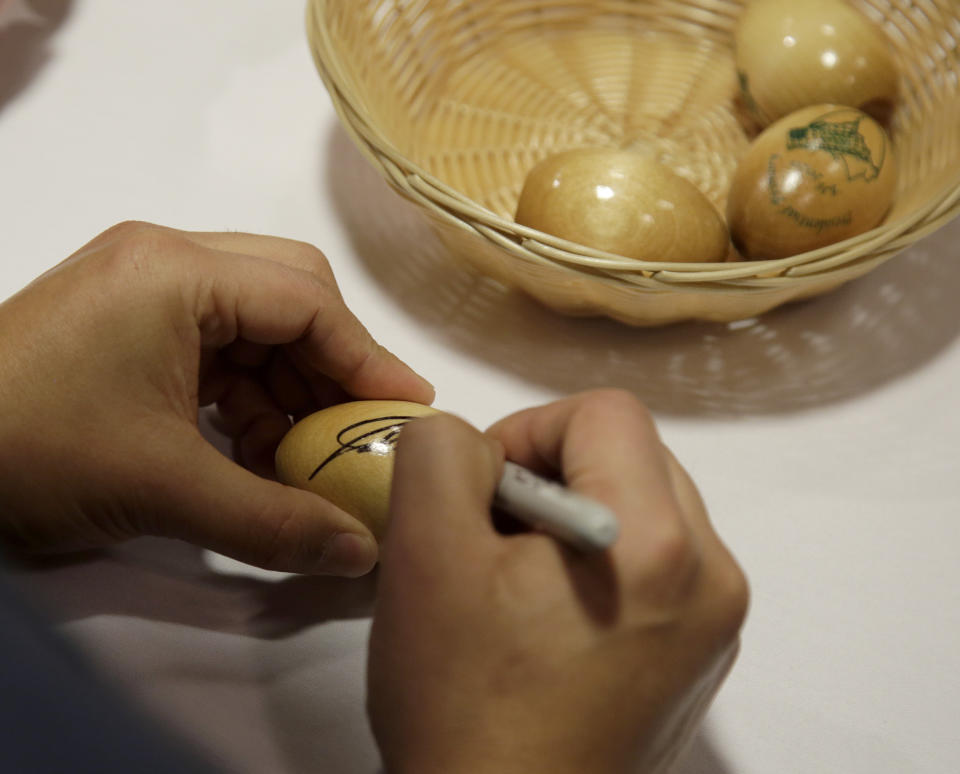 Julian Castro, former U.S. Secretary of Housing and Urban Development and candidate for the 2020 Democratic presidential nomination, signs wooden eggs before speaking at Saint Anselm College, Wednesday, Jan. 16, 2019, in Manchester, N.H. (AP Photo/Mary Schwalm)