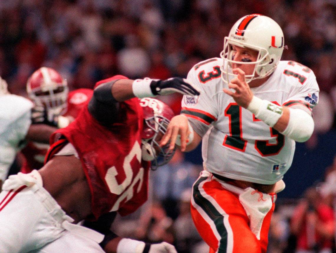 ** FILE ** In this Jan. 2, 1993 file photo, Miami quarterback Gino Torretta, right, is pressured by Alabama defender Derrick Oden after throwing a pass during the first quarter of the Sugar Bowl NCAA college football game at the Superdome in New Orleans. Alabama knocked off No. 1 Miami 34-13. (AP Photo/Bill Feig, File)