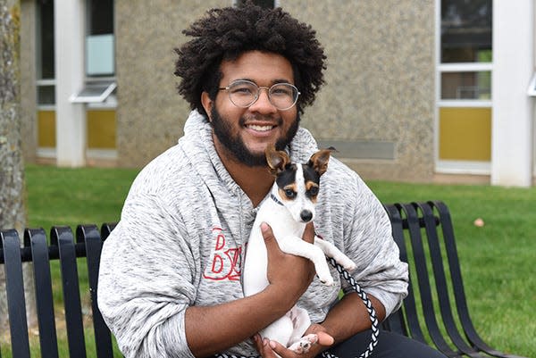 Ferris State University student Alando Steele holds his puppy Emi outside Cramer Hall. The school in Michigan is offering a floor where students can live with their pets.