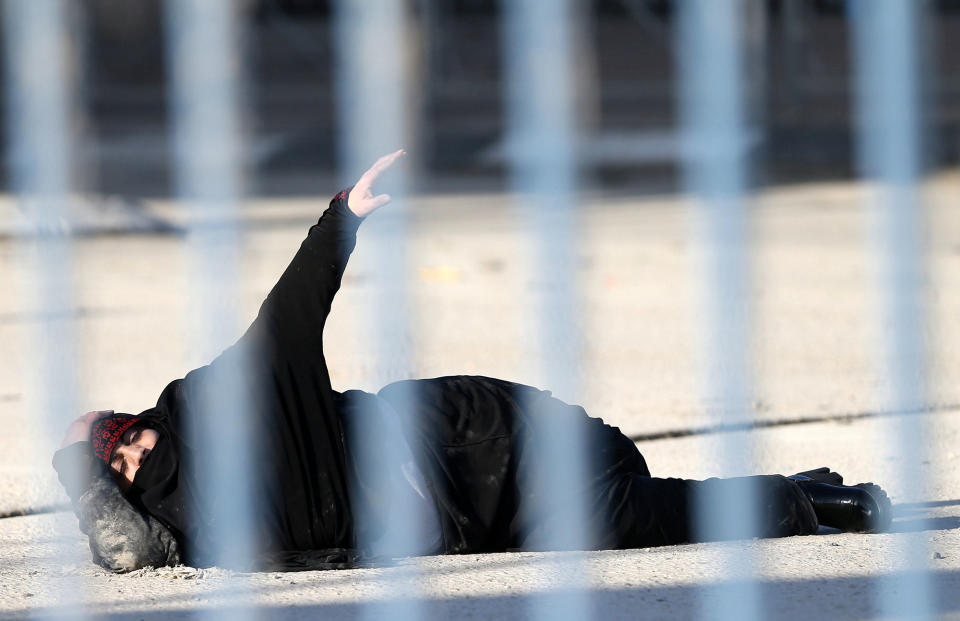 A wounded Palestinian woman lies on the ground at Qalandiya checkpoint in Ramallah, West Bank