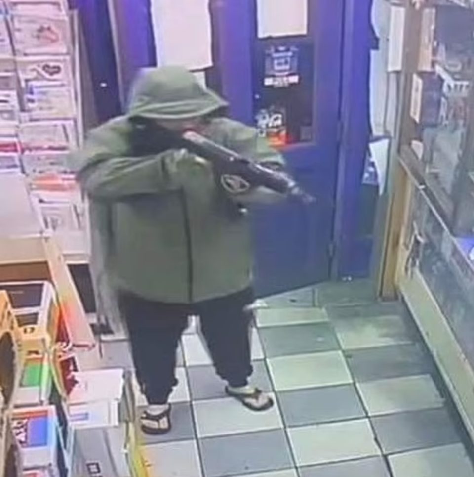 CCTV from the newsagent appears to show a hooded man carrying a large firearm (Sangha Newsagents)