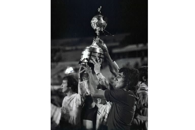 Jorge Ribolzi de Boca Juniors, al frente, sostiene el trofeo después de la tanda de penales de la final de la Copa Libertadores contra Cruzeiro en Montevideo, Uruguay, el miércoles 14 de septiembre de 1977