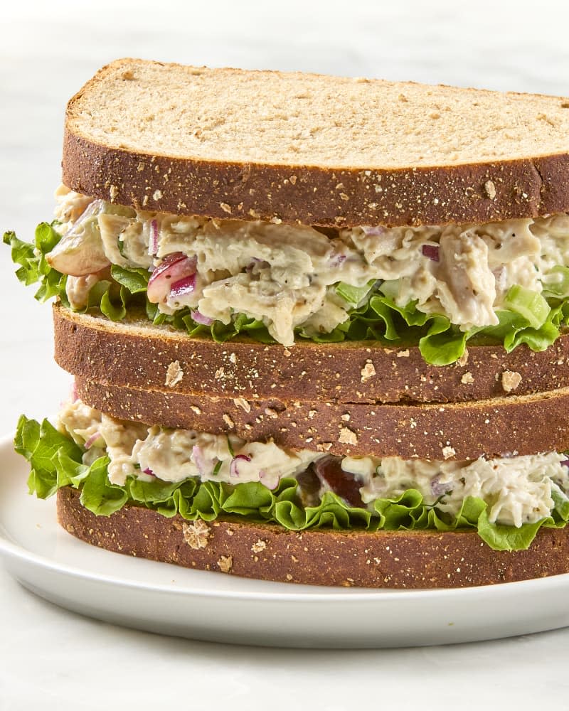 head on shot of two chicken salad sandwiches on whole wheat bread, stacked on each other.