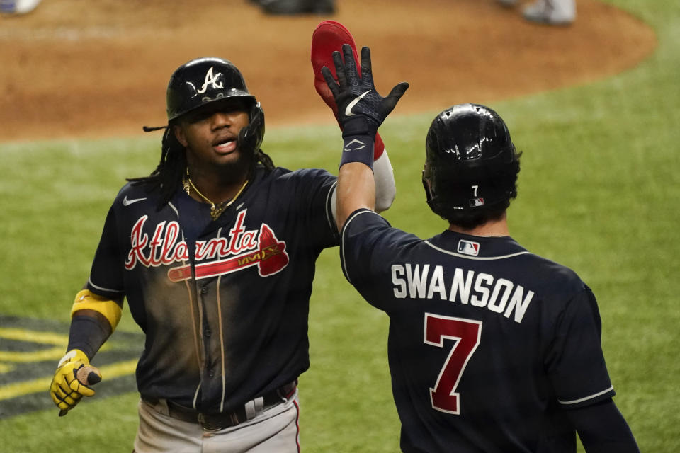 Atlanta Braves' Ronald Acuna Jr. celebrates after scoring on a walk by Travis d'Arnaud during the fifth inning in Game 2 of a baseball National League Championship Series against the Los Angeles Dodgers Tuesday, Oct. 13, 2020, in Arlington, Texas. (AP Photo/Tony Gutierrez)